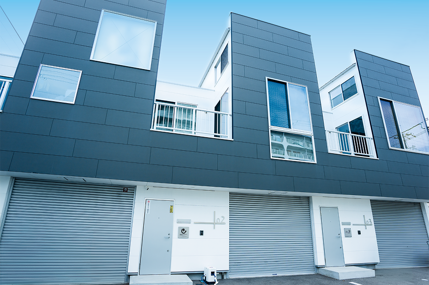 外壁とシャッター付きガレージを備えた事務所の外観